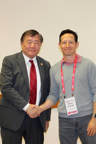 two men smiling and shaking hands