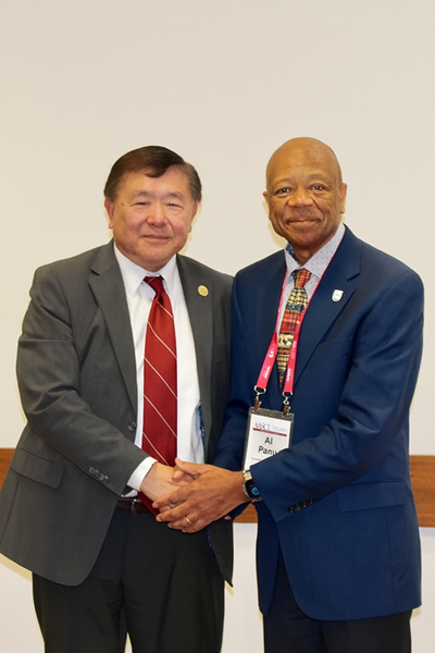 two men smiling and shaking hands