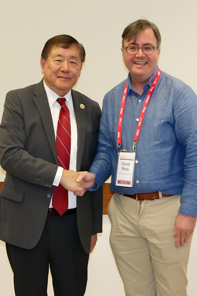 two men smiling and shaking hands